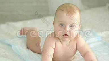 婴儿的肖像。 六个月大的男孩。 婴儿躺在床上，微笑着。